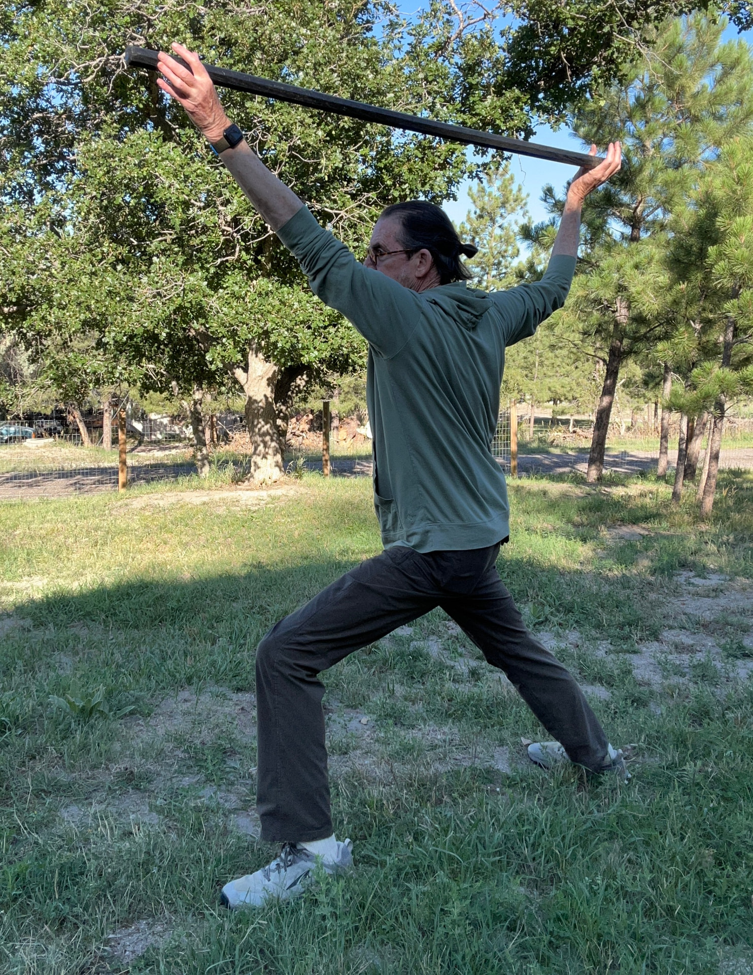 Marc Tull turning with a staff raised overhead